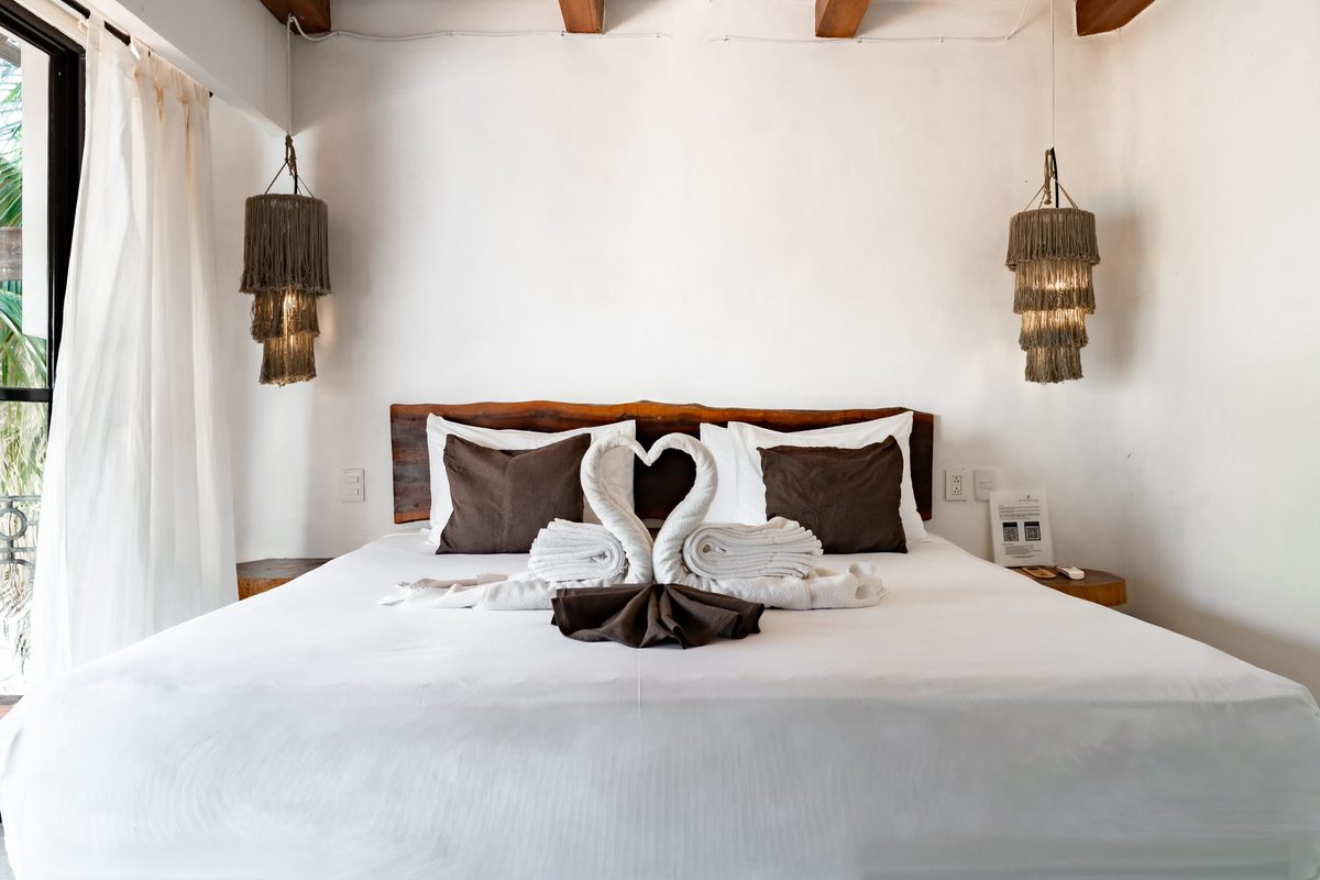 Detalle de la cama King con toallas dobladas en forma de cisne