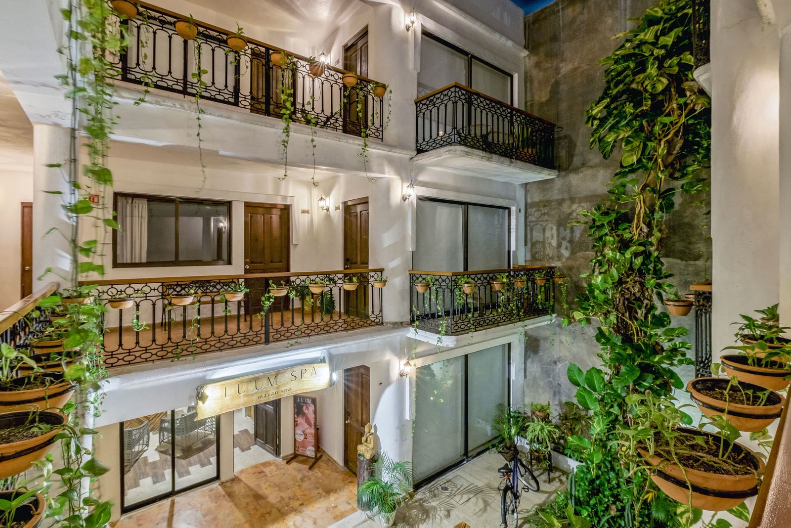 Jardín interior del hotel con balcones y Tulum Spa